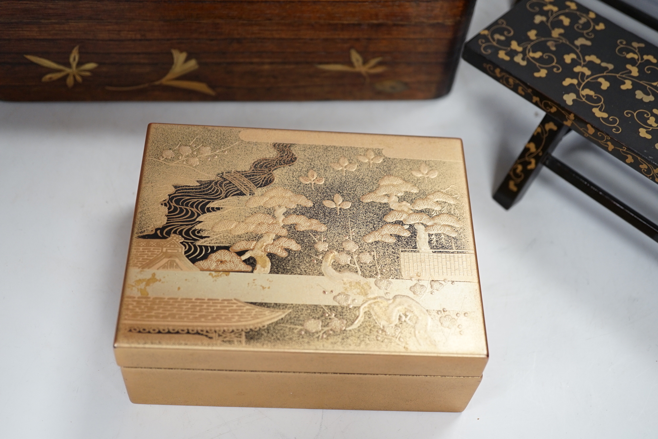 A group of Japanese lacquer wares, comprising pair of miniature benches and two boxes, Meiji period and later, largest 25cm wide